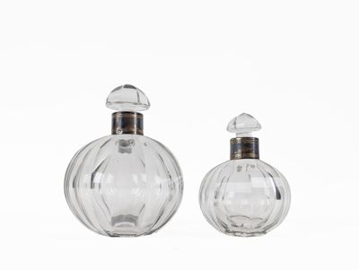 pair of clear glass perfume bottles on a white background