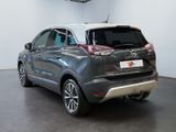 the back end of a grey car parked in a showroom