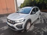 une voiture blanche garée dans un parking à côté d'un bâtiment