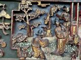 a wooden carving of a man and a woman in a garden