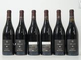 six bouteilles de vin sont alignées sur une table