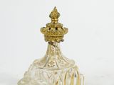 an antique glass perfume bottle with a gold top on a white surface