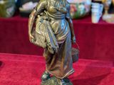 a statue of a woman holding a basket on a table