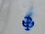 painting of a dollar sign on a white plate with blue paint
