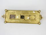 a close up of a brass plate on a white surface