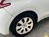 the rear end of a white car with a flat tire