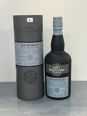 La bouteille d'alcool se trouve à côté de la boîte, sur la table.