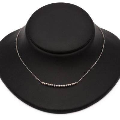 un collier noir orné de perles argentées sur un mannequin noir