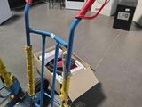 un petit chariot muni de deux poignées, posé à même le sol dans une pièce