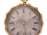 a gold pocket watch with roman numerals on it