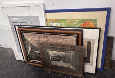 a pile of framed art on the floor next to a door