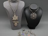 deux colliers et un collier posé sur un présentoir pour mannequin