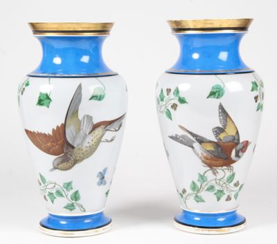 pair of blue and white vases with birds painted on them