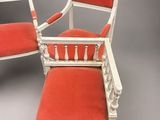pair of white painted chairs with red upholstered cushions