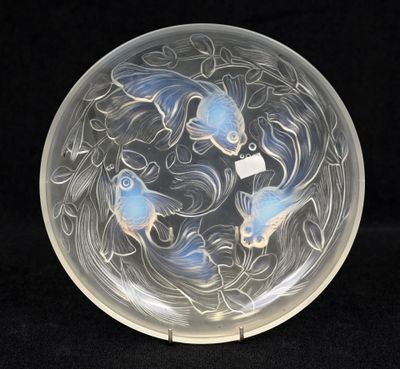 a glass plate with two fish in it on a black background