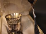 a silver spoon and a silver cup in a box