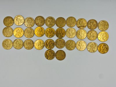 a close up of a bunch of gold coins on a white surface