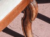 a close up of a wooden bench with a cushion on it