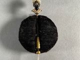 a black and gold brooch with a bird on top of it