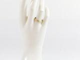 a white mannequin hand with a gold ring on it