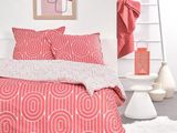 un lit recouvert d'une couette rouge et blanche