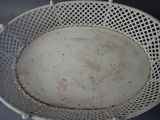 a white basket with a dirty plate inside of it