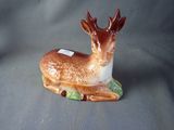 a figurine of a deer that is sitting on a table