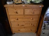 a wooden chest of drawers with flowers on top of it
