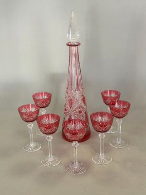 six verres à vin et une carafe posés sur une table