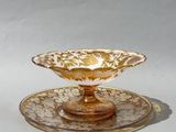 un bol et une soucoupe en verre jaune et blanc posés sur une surface blanche