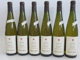 six bottles of wine are lined up in a row on a table