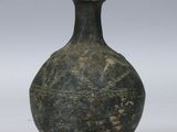 un vase vert posé sur une surface blanche