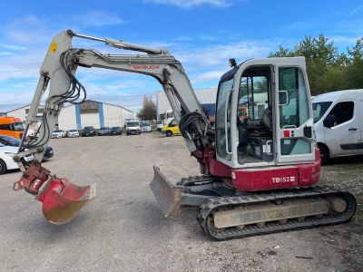 an image of a small excavator in a parking lot