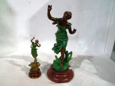 une statue représentant une femme et une figurine posées sur une table