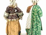 two figurines of women dressed in traditional clothing standing next to each other