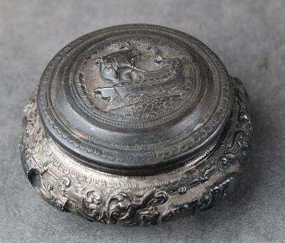 une boîte en argent sur laquelle est représenté un cheval