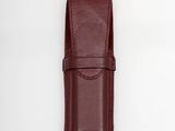 a red leather case for a small knife on a white background