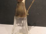 un pichet en verre avec une anse dorée posé sur une table