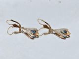two pairs of gold earrings with blue stones on them