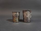 two silver cups sitting next to each other on a table