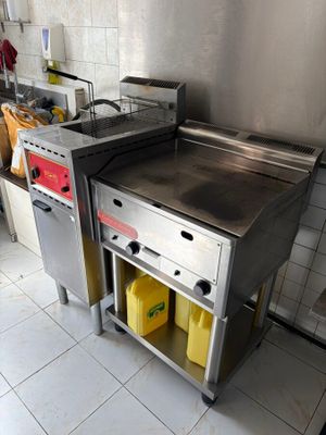 une cuisine équipée d'une cuisinière, d'un évier et d'autres appareils électroménagers