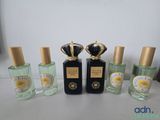 four bottles of perfume sitting on top of a table next to each other