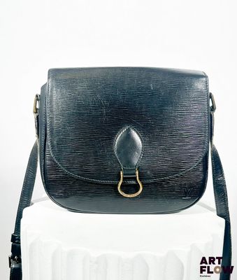 un sac à main noir posé sur une boîte blanche