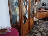 une table recouverte d'une nappe rouge et un meuble avec une porte vitrée