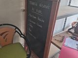 a chalk board on the table next to a chair