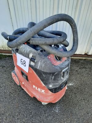un aspirateur posé par terre, muni d'un tuyau