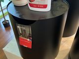 two black trash cans sitting on top of a wooden table