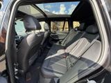 the back seats of a car with the door open and the driver ' s seat down