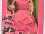 poupée Barbie en robe rose, dans une boîte rose ornée de fleurs roses