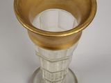 a glass vase with a gold rim on a white surface